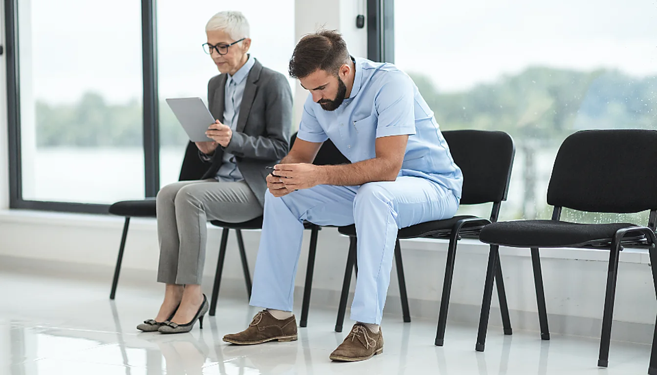 Dos personas esperando juntas en la sala de espera de una consulta médica